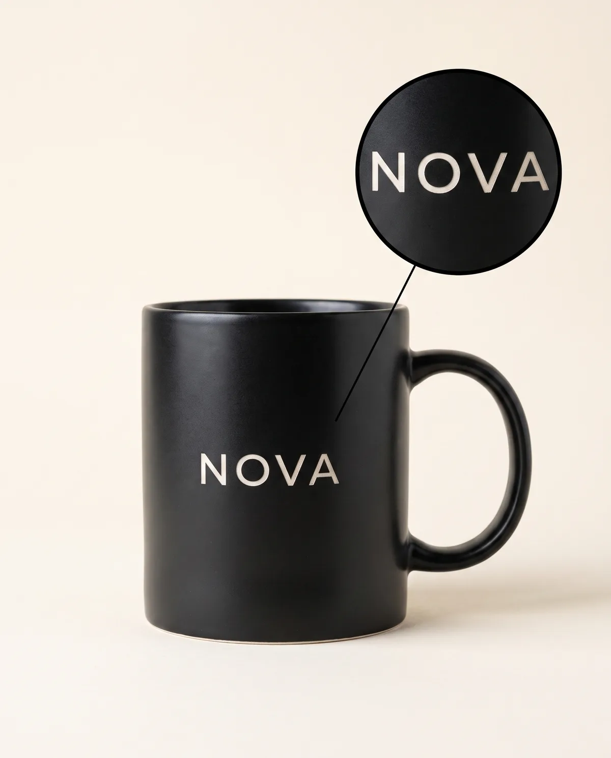 Matte black ceramic mug, laser-engraved NOVA sample mark with zoom loupe