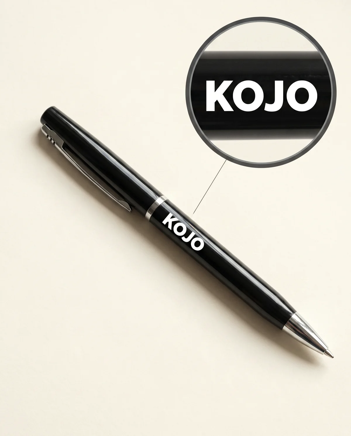 Black lacquered metal ballpoint pen with white printed KOJO sample mark, detail loupe