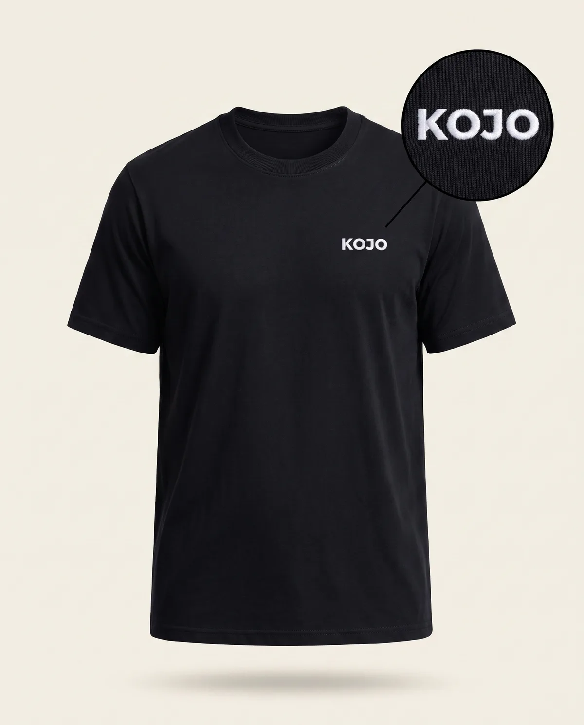 Black crew tee, white embroidered KOJO sample mark with zoom loupe